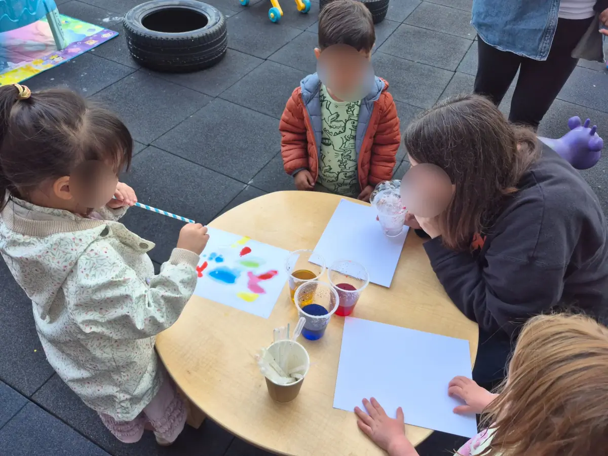 Village Scholars Preschool photo: painting with careful hands and bright colours